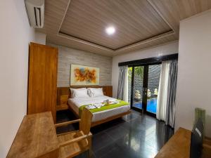 a bedroom with a bed and a large window at Rahayu Guest House Seminyak in Seminyak