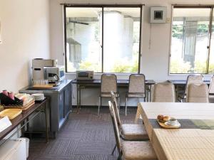 a room with chairs and a table with a coffee maker at Business Hotel Fujimi in Fujiyoshida