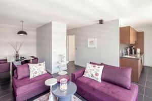 a living room with purple couches and a kitchen at Tempologis Grenoble in Grenoble