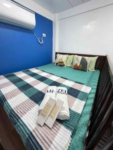 ein Bett in einem Zimmer mit zwei Büchern darauf in der Unterkunft Arzel's Tiny House in Mangatarem + 26 Fotos