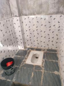ein Badezimmer mit einer Bodentoilette und einem Eimer in der Unterkunft Vicky camps & Adventures in Shillong