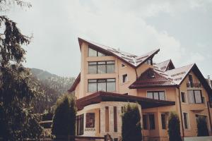 a house with a mountain in the background at Denisa Boutique in Poiana Brasov