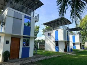 ein Haus mit blauen Türen und einer Palme in der Unterkunft Arzel's Tiny House in Mangatarem