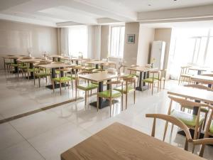 a dining room with tables and green chairs at GreenTree Inn Suqian Suyu District Red Star Macalline in Zhuoxu