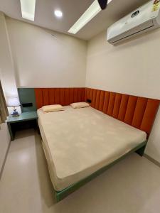 a small bedroom with a bed and a red headboard at Aesthetic 1BHK Elite, Indore in Indore