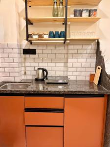 a kitchen with orange cabinets and a sink at Aesthetic 1BHK, Indore in Indore