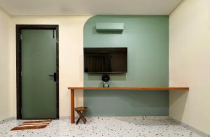 a room with a green wall with a table and a green door at Aesthetic 1BHK Elite, Indore in Indore