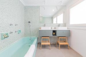 a bathroom with a blue tub and two chairs at Errekaondo - baskeyrentals in Plentzia +75 photos