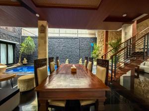 a dining room with a wooden table and a pool at Rahayu Guest House Seminyak in Seminyak