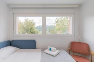a bedroom with two beds and a window at Errekaondo - baskeyrentals in Plentzia