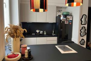 Una cocina con encimera negra y refrigerador. en Bright and comfortable stay in the heart of Lyon, en Gare des Brotteaux