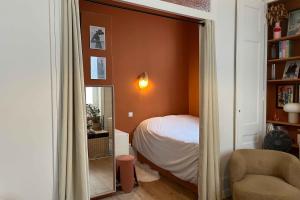 un dormitorio con una cama y un espejo en Bright and comfortable stay in the heart of Lyon, en Gare des Brotteaux