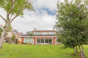 a house with a large yard with trees at Errekaondo - baskeyrentals in Plentzia