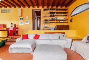 a living room with white couches and red pillows at Casa Gelsomino in Scandicci