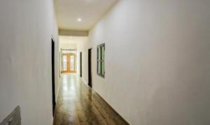een hal met witte muren en een houten vloer bij FabHotel Rajhans in Gurgaon