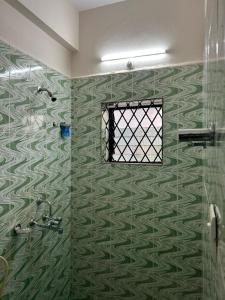 a bathroom with a shower with a window at Shree Stay in Anjuna