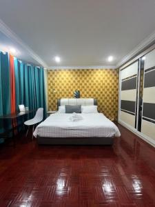 a bedroom with a large bed and a desk at GL Homestay in Sibu
