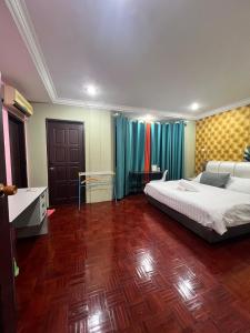a bedroom with a large bed and a wooden floor at GL Homestay in Sibu