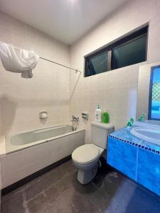 a bathroom with a toilet and a tub and a sink at GL Homestay in Sibu +14 photos