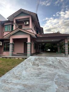 a pink house with a driveway in front of it at GL Homestay in Sibu