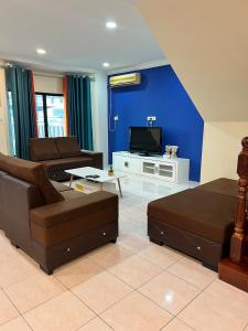 a living room with a couch and a tv at GL Homestay in Sibu +14 photos