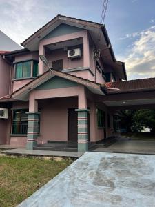 a pink house with a driveway in front of it at GL Homestay in Sibu