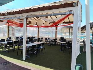 a pavilion with tables and chairs under a tent at Le SPLENDIDE in Fréjus