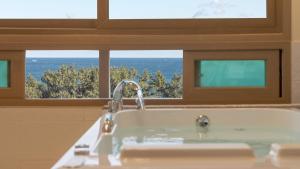 a bathroom with a tub with a view of the ocean at Sokcho pensionbyeol in Sokcho