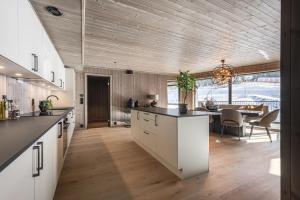 een keuken met witte kasten en een houten plafond bij Brand new luxury apartment by the slopes, Hemsedal in Kyrkjebøen