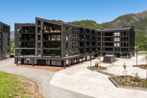 een afbeelding van een gebouw met bergen op de achtergrond bij Brand new luxury apartment by the slopes, Hemsedal in Kyrkjebøen