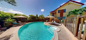 a swimming pool in front of a house at L'Oasis de L'Anse Bleue in Le Diamant