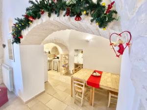 Una cocina y un comedor con una mesa y adornos navideños. en Trullo Stella Luxury Trullo, en Alberobello