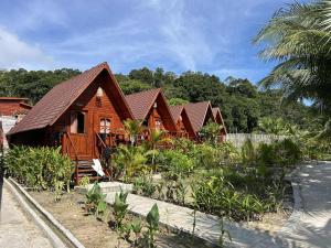 a row of wooden homes with trees in the background at Coco Bungalows in Koh Rong Sanloem