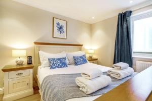 a bedroom with a bed with towels on it at Tranquil Shores in Carbis Bay