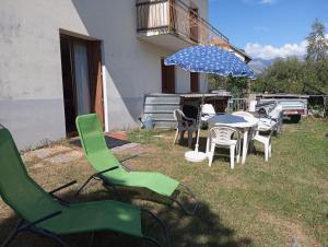 - un groupe de chaises et une table avec un parasol dans l'établissement Chez Marinette, à Saint-Jean-Saint-Nicolas