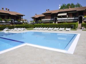a swimming pool with chairs and a building at Amazing holiday home in Lazise with swimming pool in Lazise