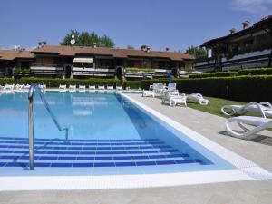 a large swimming pool with chairs and a house at Amazing holiday home in Lazise with swimming pool in Lazise