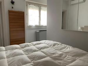 ein weißes Bett in einem Zimmer mit einem Spiegel in der Unterkunft Casa Miki in Sarnico
