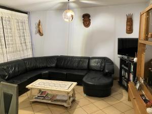a living room with a black leather couch and a coffee table at Le Nazareth in Lyon