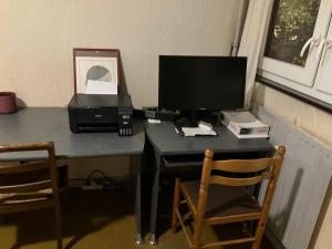 a desk with a computer monitor and a printer on it at Le Nazareth in Lyon
