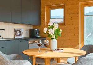 康斯坦茨seeglueck ROSENHOF - naturnah Wohnen im Holz100-Vollholzhaus mit Whirlpool und Garten的厨房配有桌子和2个酒杯 更多17张照片