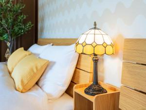 a lamp on a night stand next to a bed at NicoRoom601-Convenient location in Takamatsu