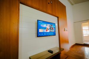 a flat screen tv hanging on a wall at Anvitha Mansions in Attigundi