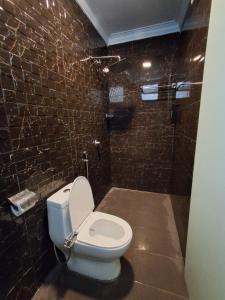 クアラルンプールにあるHotel AL Aminのレンガの壁に白いトイレが付いたバスルーム +66枚の写真