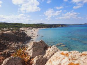 a beach with people on the sand and the water at Case del centro storico Santa Teresa Gallura in Santa Teresa Gallura