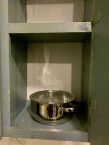 タモンにあるCozy 1 bedroom, 1 bathroom Pedro's Heights Villaのキャビネットの棚にある銀色の鍋