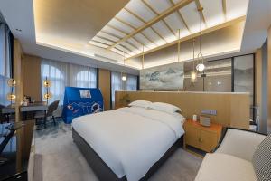 een slaapkamer met een groot wit bed en een bureau bij Floral Luxury Hengdian Jiuqilu B&B in Longfengshan