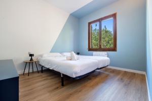 サロウにあるClauhomes CostaMarの白いシーツと窓のあるベッドのある寝室