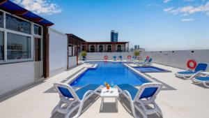 a pool with chairs and a table on a patio at Donatello Hotel in Dubai