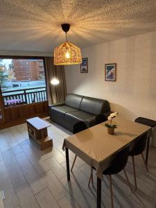 a living room with a couch and a table at Meijotel A N26 - ST5C in Les Deux Alpes